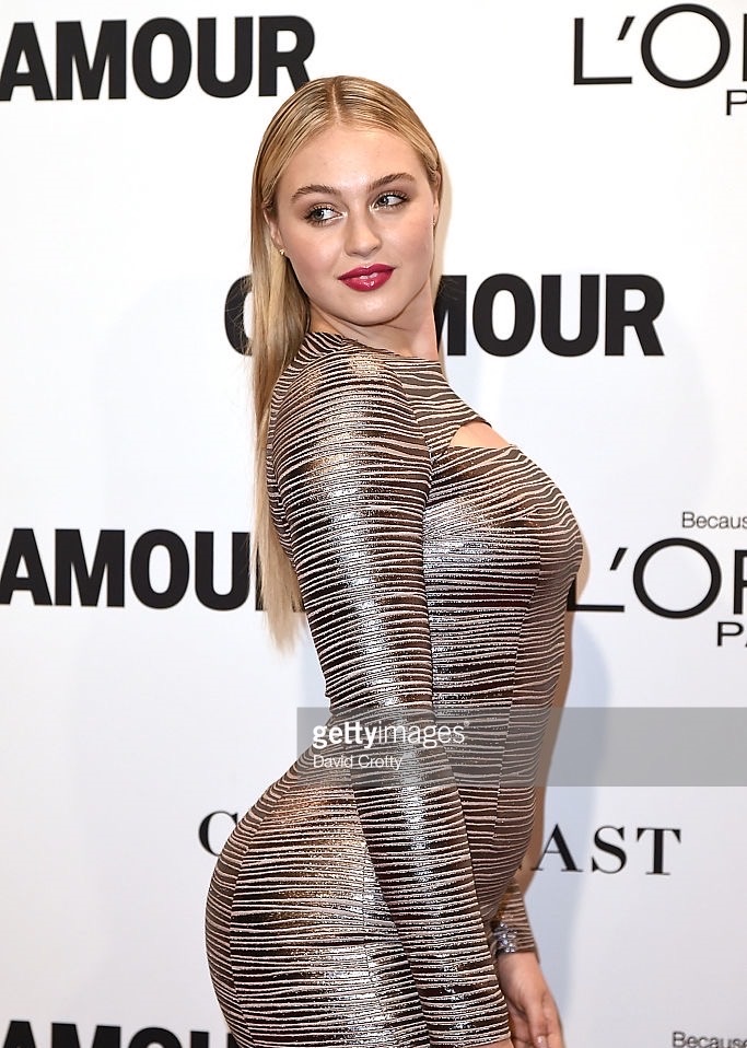 Iskra is on the red carpet in a long, metallic dress and black heels.