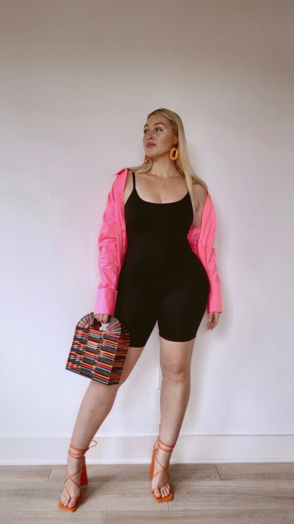 Iskra posing in black Good American bodysuit styled with colorful statement pieces